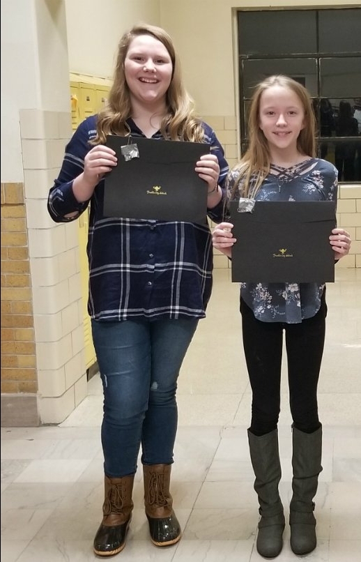 two girls holding certificates